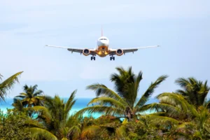 Airplane flying over tropical island scenery representing travel from Malaysia to Bali and Gili Trawangan