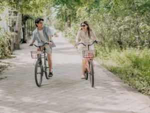 A tourist riding a rental bicycle on a quiet beachside road with no motor vehicles in Gili Trawangan.